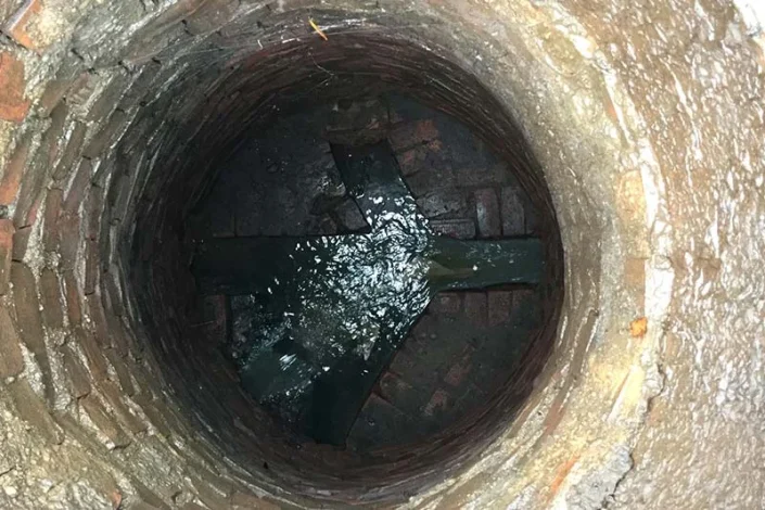 Pouring lime in the sewer well
