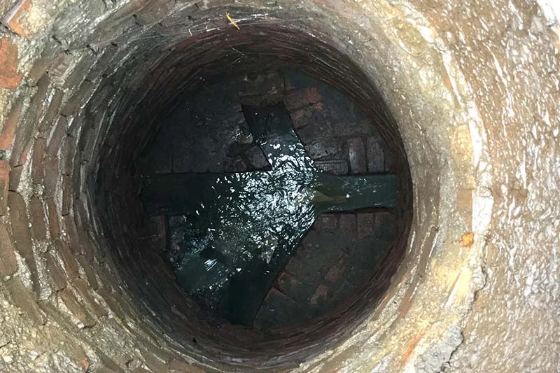 Pouring lime in the sewer well